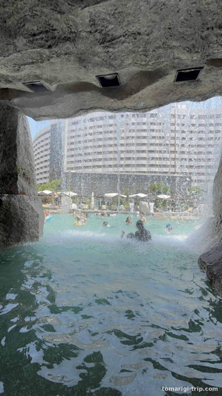 メインプールの滝。くぐって中に入れます。右は滝の内側から、水のカーテン越しに見た景色