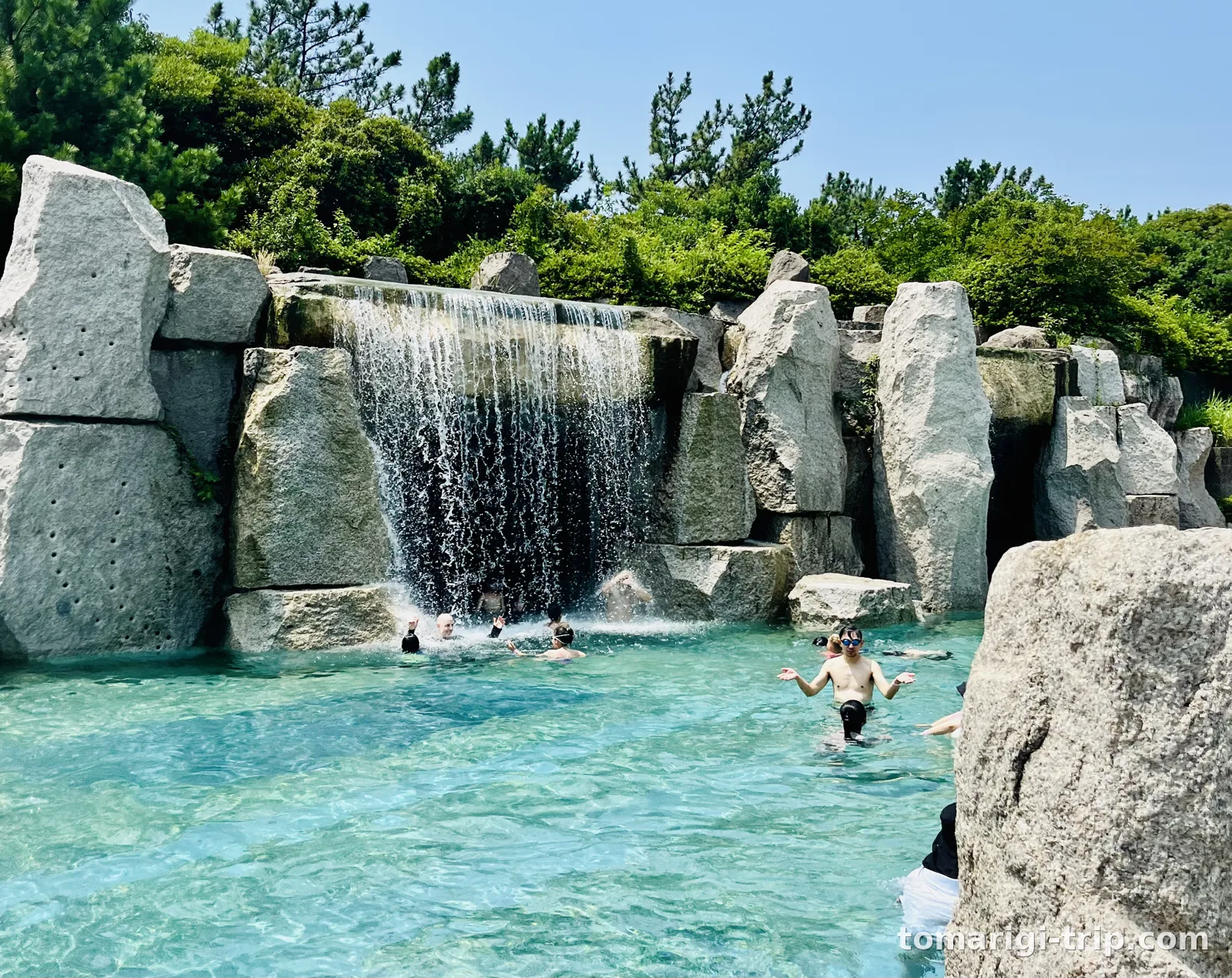 メインプールの滝。くぐって中に入れます。右は滝の内側から、水のカーテン越しに見た景色