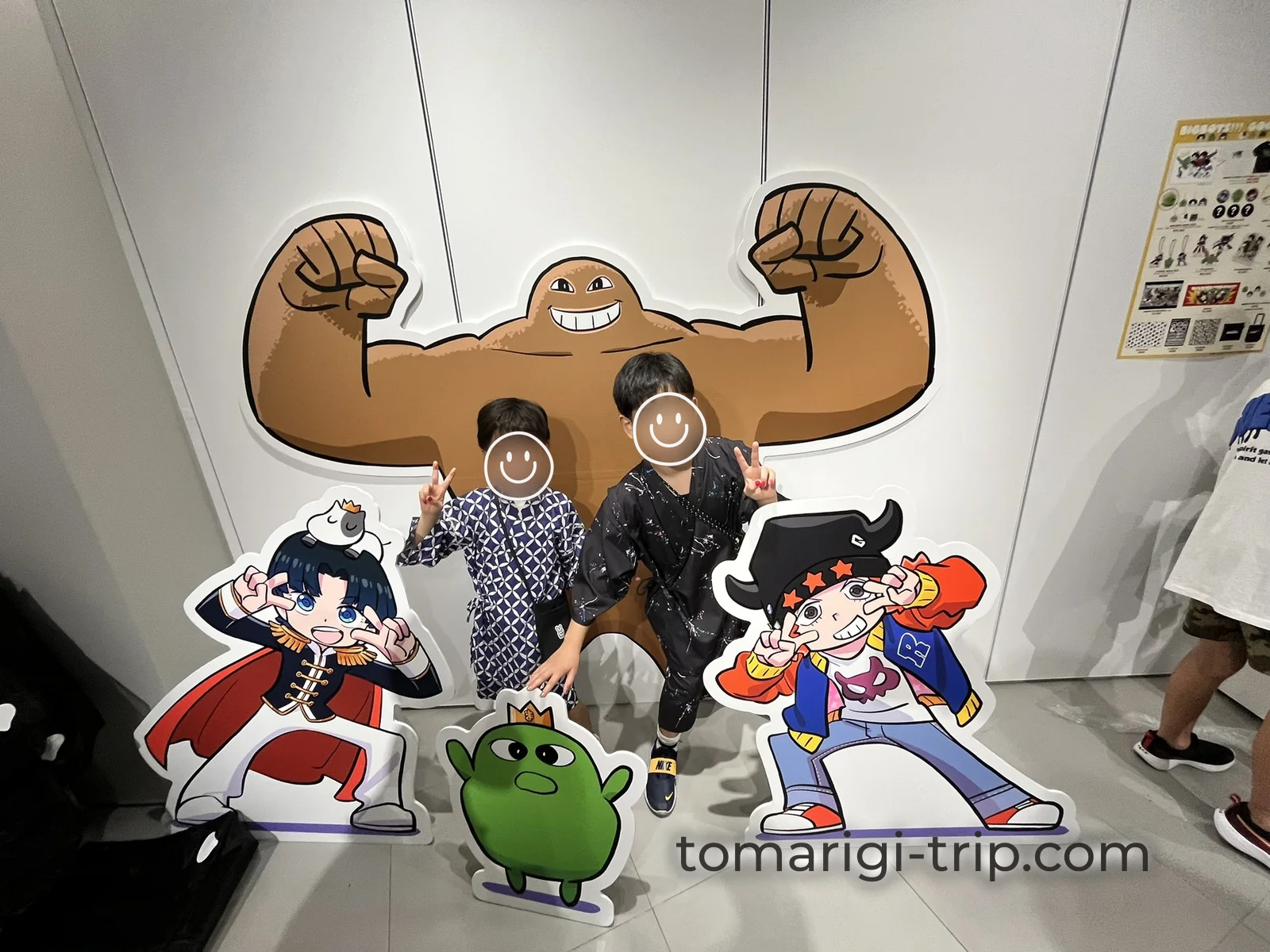 看板の前で記念撮影。3人のキャラクターに囲まれてご満悦